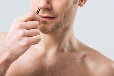 Cropped View Of Man Plucking Hair With Tweezers From Nose