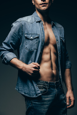 cropped view of sexy man posing in denim shirt isolated on greyの写真素材