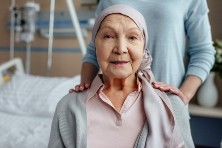 senior woman in kerchief with daughter on background in hospitalの写真素材