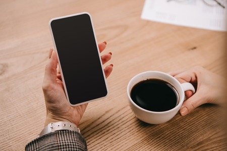 cropped view of businesswoman using smartphone on coffee breakの写真素材