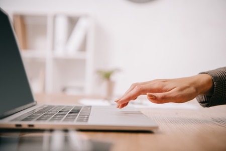 cropped view of businesswoman typing on laptop at workplaceの写真素材