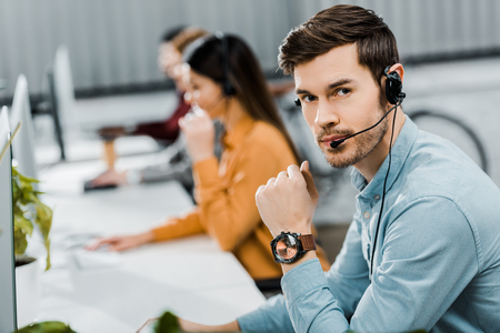 selective focus of call center operator in headset in officeの写真素材