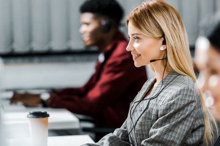 selective focus of smiling call center operator working in officeの写真素材
