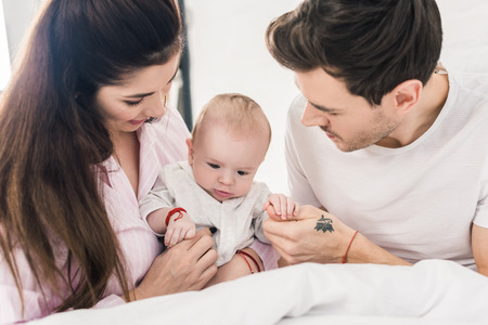 portrait of young parents with little son at home