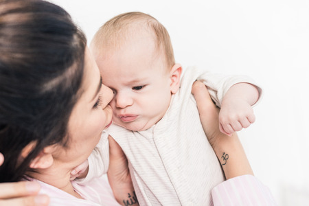 portrait of mother holding little son in hands