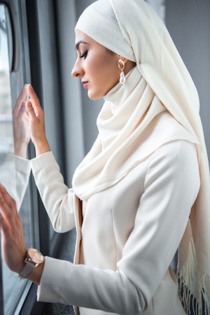 profile portrait of beautiful young muslim woman looking at windowの写真素材