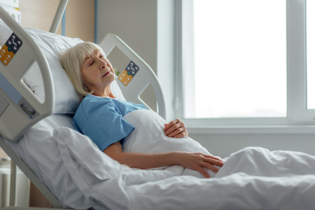 selective focus of senior woman sleeping in hospital bed