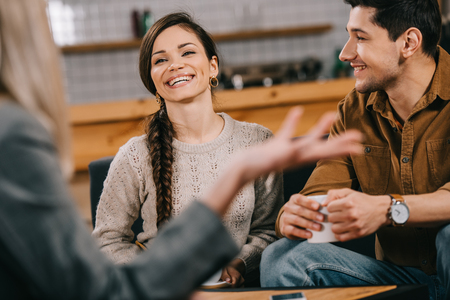 selective focus of cheerful friends chatting in cafeの写真素材
