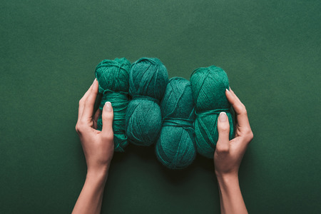 cropped shot of woman holding yarn on green backdropの写真素材