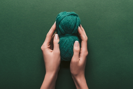 cropped shot of woman holding yarn on green backdropの写真素材