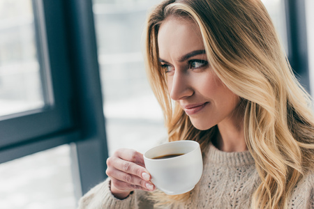 cheerful woman smiling while holding cup with teaの写真素材