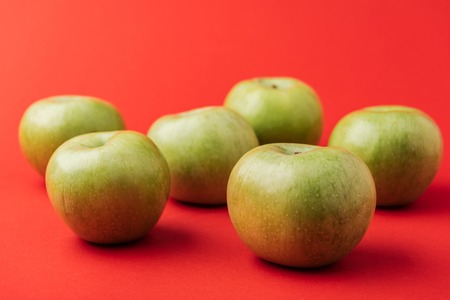 large ripe green apples on red backgroundの写真素材