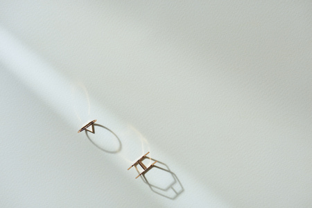 top view of two beautiful luxury rings on white surface with sunlightの写真素材