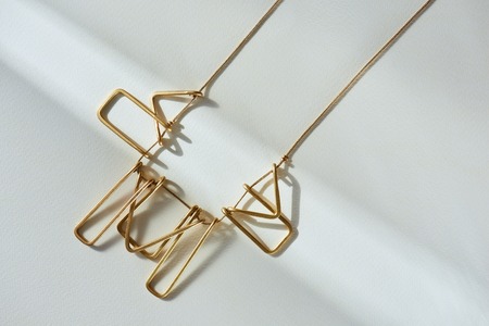 elevated view of beautiful luxury necklace on white surface with sunlightの写真素材