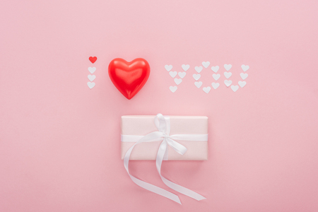 top view of gift box and 'i love you' lettering made of paper hearts isolated on pink, st valentines day conceptの写真素材