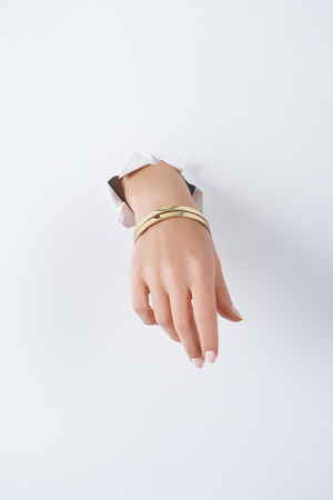 cropped image of woman holding hand with beautiful luxury bracelet through white paperの写真素材