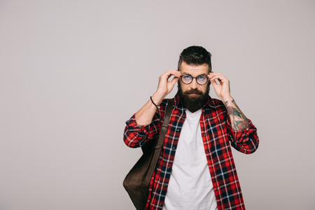 handsome bearded man in eyeglasses with backpack, isolated on greyの写真素材