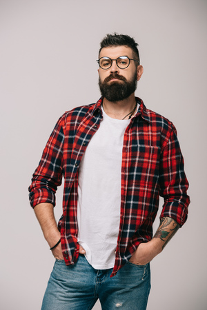 confident bearded man posing in checkered shirt isolated on greyの写真素材