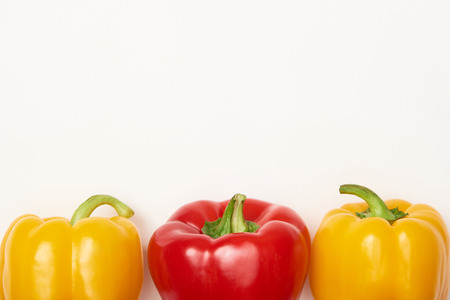 Studio shot of red and yellow bell peppers on white background