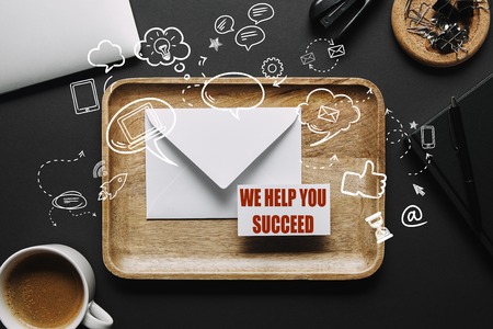 flat lay with Wooden tray with envelope and business card with we help you succeed lettering on...
