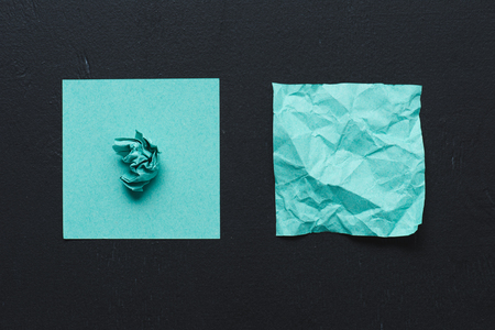 Top view of turquoise crumpled paper on black background, think different conceptの写真素材