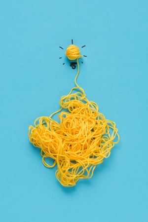 top view of light bulb sign made of yellow yarn on blue background, ideas conceptの写真素材