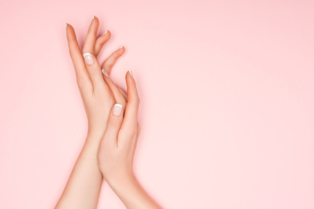 cropped view of female hands isolated on pinkの写真素材