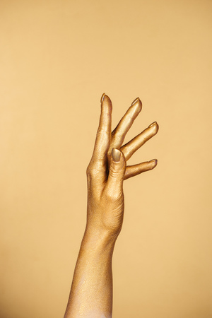 cropped view of female painted hand isolated on goldの写真素材