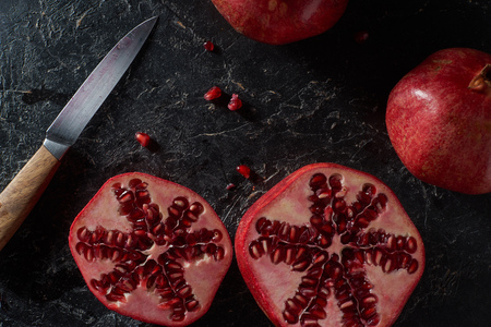 Top view of cut pomegranates with knifeの写真素材