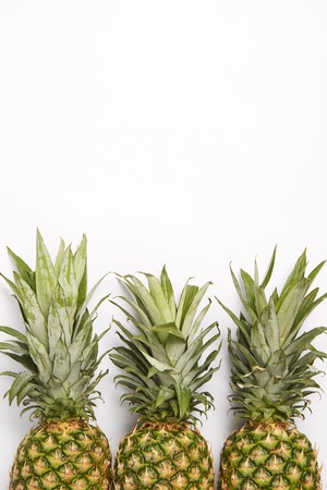 top view of organic fresh pineapples on white  backgroundの写真素材