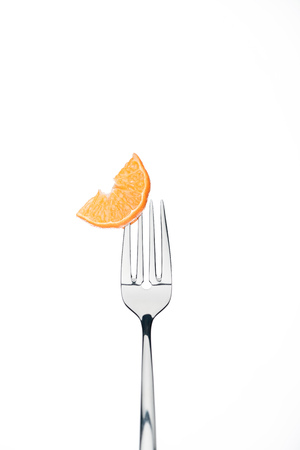 slice of fresh ripe juicy tangerine on fork isolated on whiteの写真素材