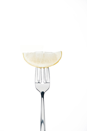 half slice of fresh ripe juicy lemon on fork isolated on whiteの写真素材