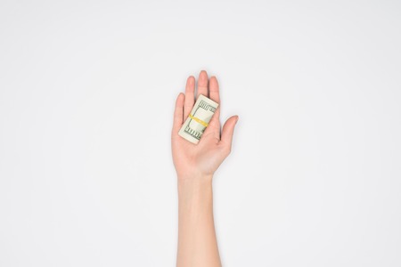cropped view of woman holding money roll in open palm isolated on greyの写真素材