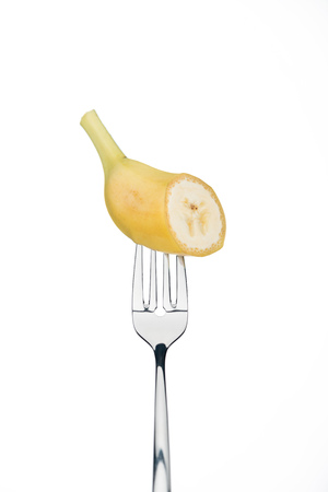 piece of fresh sweet banana on fork isolated on whiteの写真素材