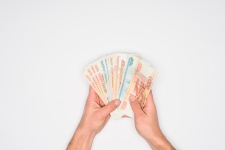 cropped view of man holding russian banknotes in hands isolated on greyの写真素材