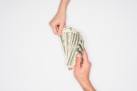 cropped view of couple sharing dollars isolated on greyの写真素材