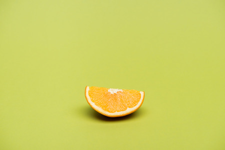 Slice of fresh ripe juicy orange on green backgroundの写真素材
