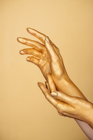 partial view of female painted hands isolated on goldの写真素材