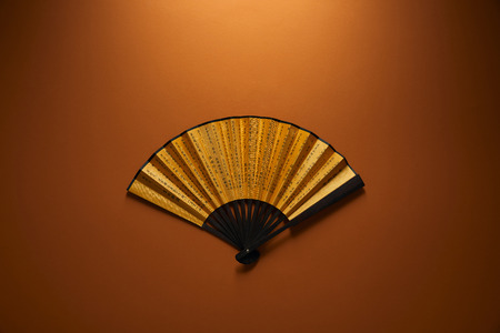 top view of decorative black and golden fan with hieroglyphs on brown background, chinese new year conceptの写真素材