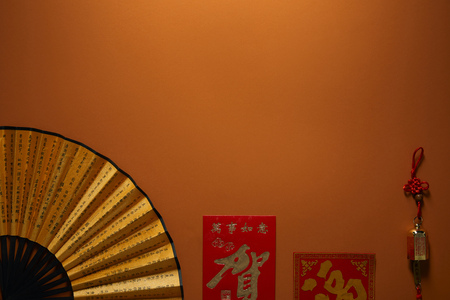 top view of fan with hieroglyphs on brown background, chinese new year compositionの写真素材