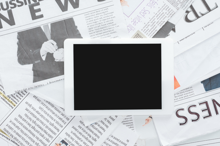 top view of tablet with blank screen on business newspapersの写真素材