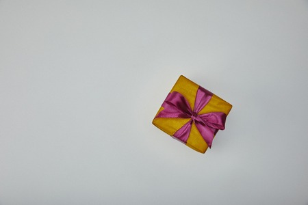 Top view of wrapped gift with purple ribbon isolated on grey backgroundの写真素材