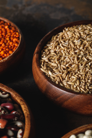 close up of oat groats in wooden bowl on tableの写真素材