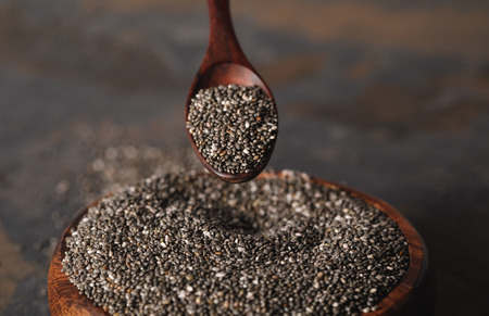 selective focus of wooden spoon and chia seeds in bowlの写真素材
