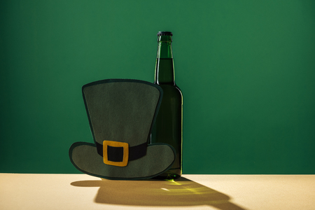 beer bottles and paper hat isolated on green, st patrick day conceptの写真素材