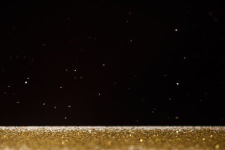 table with bright golden sparkles isolated on black