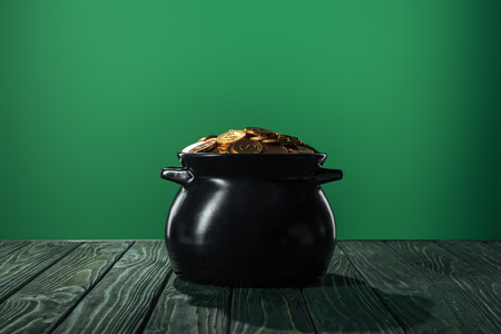 golden coins in black pot isolated on green, st patrick day conceptの写真素材