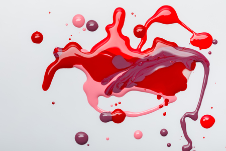 top view of abstract and colorful spilled nail polish isolated on greyの写真素材
