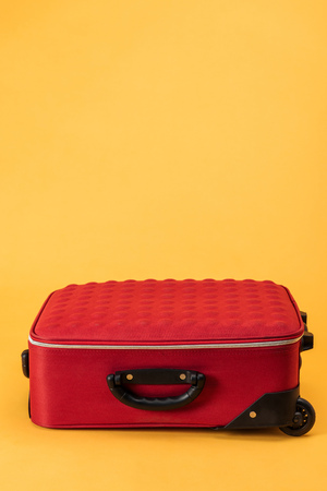 travel bag with wheels on yellow backgroundの写真素材