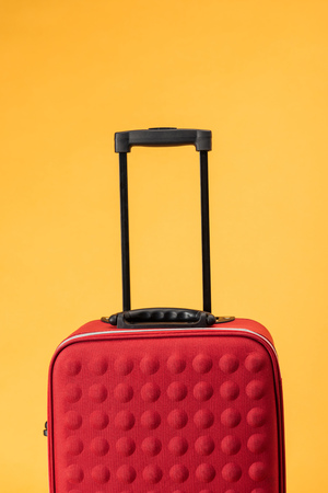red travel bag with handle isolated on yellowの写真素材